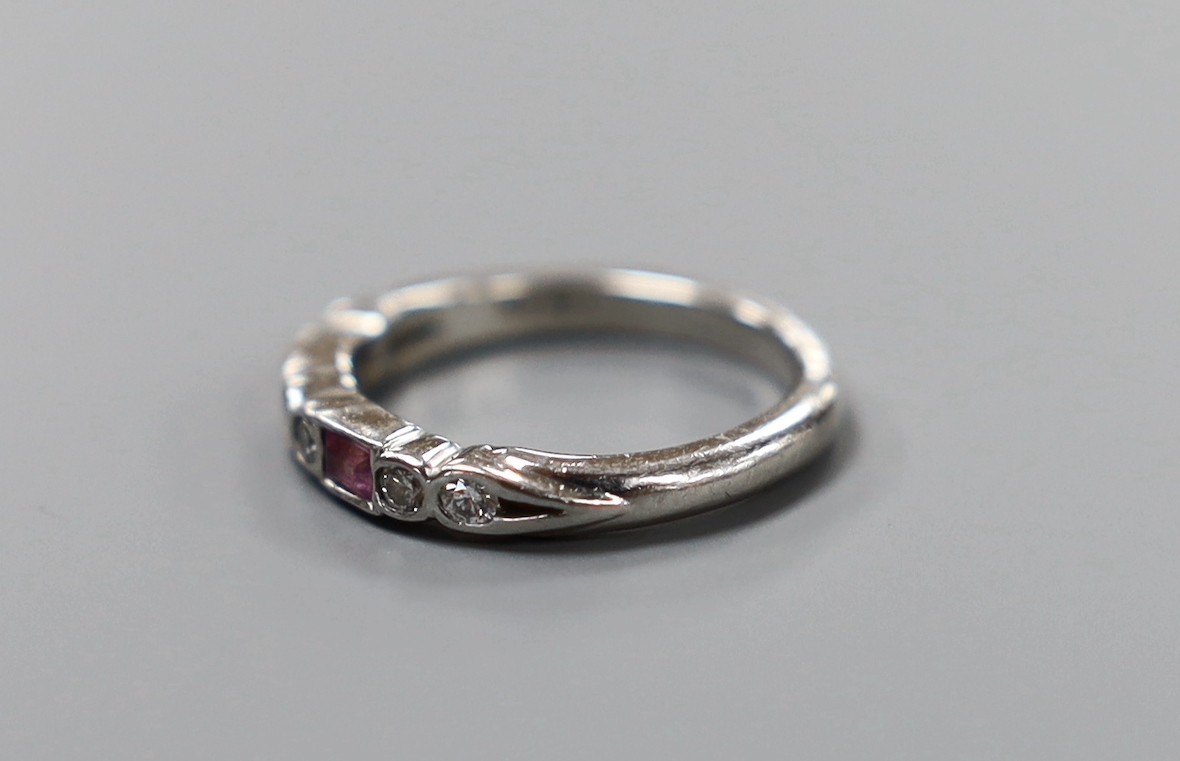 A modern platinum, two stone pink sapphire and six stone diamond set half hoop ring, size H, gross weight 3.9 grams.